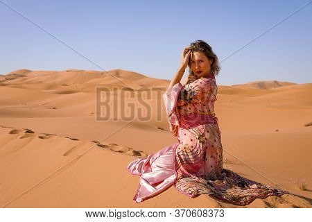 Girl In Moroccan Dress In Sahara Desert.