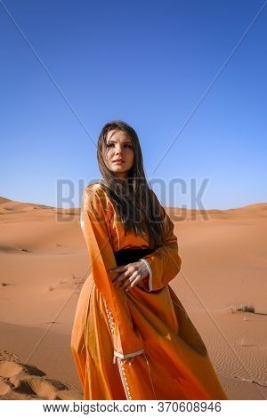 Beautiful Young Girl In Moroccan Dress In Sahara Desert.