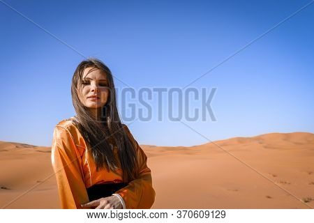 Beautiful Young Girl In Moroccan Dress In Sahara Desert.