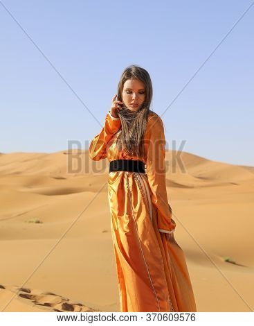 Beautiful Young Girl In Moroccan Dress In Sahara Desert.