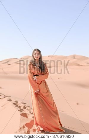 Beautiful Young Girl In Moroccan Dress In Sahara Desert.