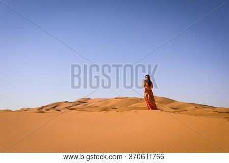 Beautiful Young Girl In Moroccan Dress In Sahara Desert.