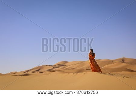 Beautiful Young Girl In Moroccan Dress In Sahara Desert.