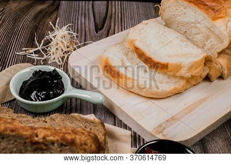 Close Up Fresh Homemade Loafs Bread And Sliced Bread On Cutting Board With Jam Strawberry On Wooden 