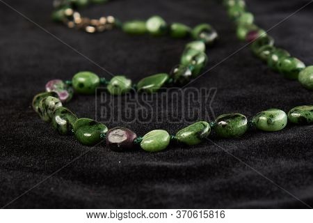 Beads From Zoisite Semiprecious Stone On Black Velor. Close Up