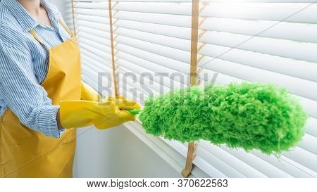 Young Female Spring Cleaning House Interior Holding A Duster For Wiping Dust Dusting Furniture At Ho