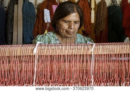 Oaxaca, Mexico - 2019-11-30 - Woman Works At Her Loom Making A New Blanket.