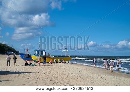 Rewal, Poland - September 05, 2019: Holidaymakers And Fishing Boats On The Beach Of Rewal On The Pol
