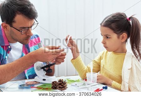 Image Of A Little Girl With Father Doing Science Experiments In The Laboratory. Dad And Daughter Stu