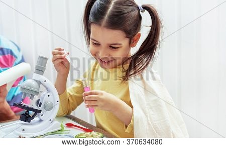 Indoor Image Of Smiling Little Girl Doing Science Experiments In The Laboratory With Father. Dad And