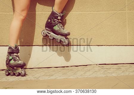 Woman Wearing Roller Skates In Town. Female Being Sporty During Summer Time.