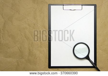 A Tablet With A White Sheet Of A4 Format With Magnifier On A Beige Craft Paper. Concept Of Analysis,