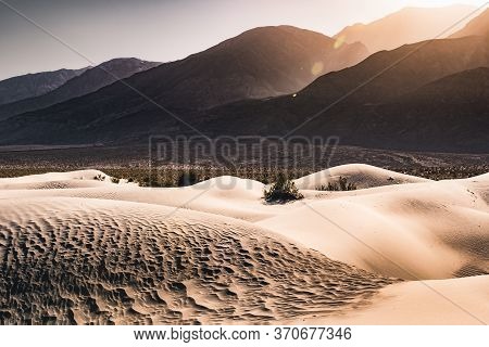 Death Valley Sand Dunes At Sunset With The Mountains As Backgrounds. A Few Footprints