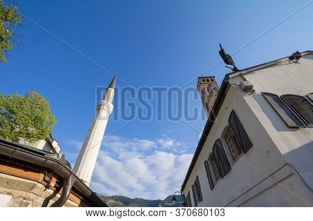 Minaret Of The Gazi Husrev Begova Mosque Next To The Clocktower Of Sarajevo Bazaar, Called Bascarsij