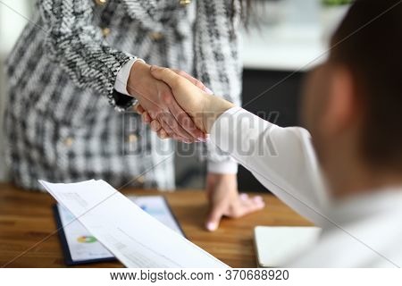 Close-up Of Businesswoman Shaking Hands With Guest. Young Woman In Presentable Luxury Suit In Office