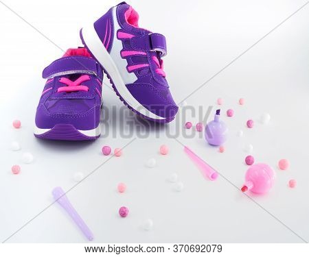 Close Up View Of Violet Pink Childrens Sneakers With Pink And White Balls And Felt-tip Pens At Peach