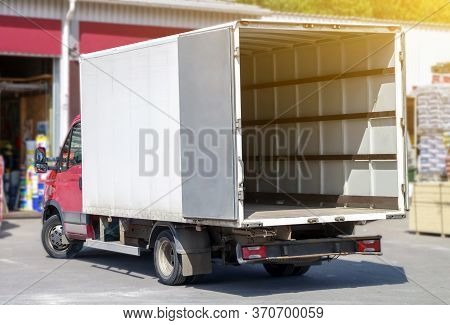 Small Truck With Red Cab Stands With Open Empty Body Ready For Loading Cargo. Lipping Path Is Includ