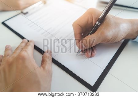 Person Signing Signature Into Employment Agreement Contract.