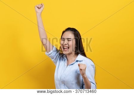 Beautiful Young Woman Celebrating Success Isolated On Yellow Background. Studio Shot.