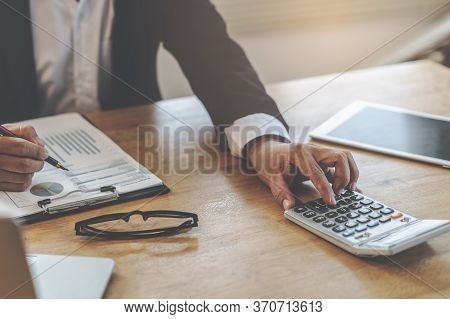 Close Up View Hands Of Businessman Using Calculator And Doing Accounting With Graph And Documents On