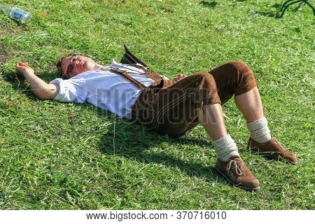 Bad Hindelang, Bavaria, Germany - September 10 2011: Mountain Farmer Lying On Ground Relaxing After 