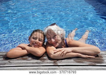 Grandmother with grandkid in resort swimming-pool