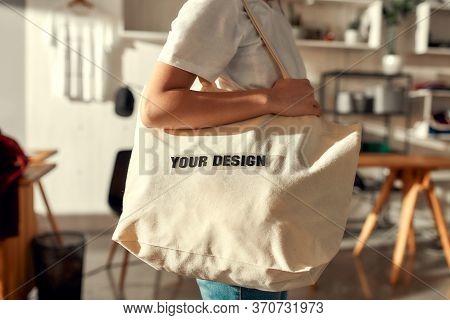 Cropped Shot Of Female Worker Posing With Custom Shopper Bag In The Store. Young Woman Working At Cu