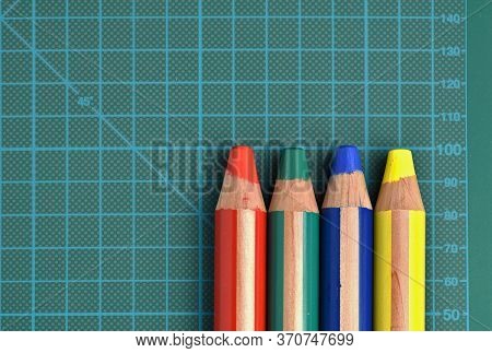 Rgby (red, Green, Blue, Yellow) Colored Pencils On A Cutting Mat