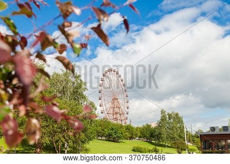 View Of The New Big Ferris Wheel Through The Branches Of Trees With Colorful Foliage On The Mikhailo