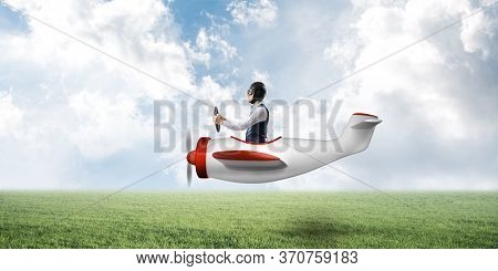 Man In Airplane Flying Low Above Green Meadow. Aviator Driving Small Propeller Plane. Emotional Pilo