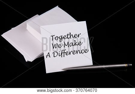 Conceptual Hand Writing Together We Make The Difference Message On A White Sticker With Pen On A Bla