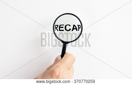 Male Hand Holding Magnify Glass With Word Recap Isolated On White Wall
