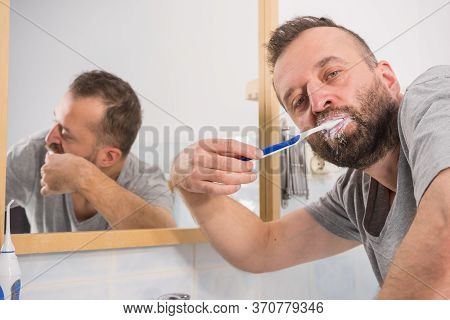 Funnny Guy Taking Care Of His Oral Hygiene, Brushing Teeth During Morning Bathroom Routine.