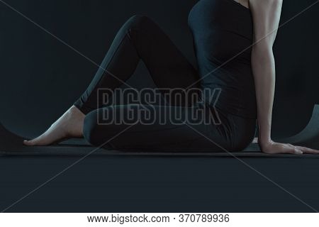 Young Woman Practicing Yoga Pose Stratching . Sport Workout Fitness. Yoga Mat And Leggins On A Dark 