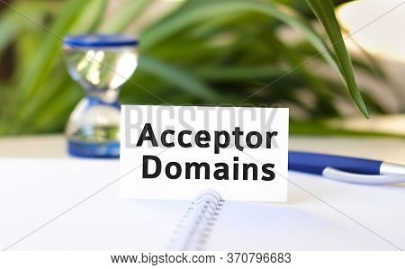 Acceptor Domain Seo Business Concept Text On A White Notebook And Hourglass, Blue Pen, Green Flowers