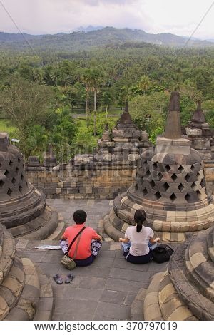Borobudur, Indonesia - June 10, 2013: Couple Meditate At Borobudur Temple, Java, Indonesia. Candi Bo