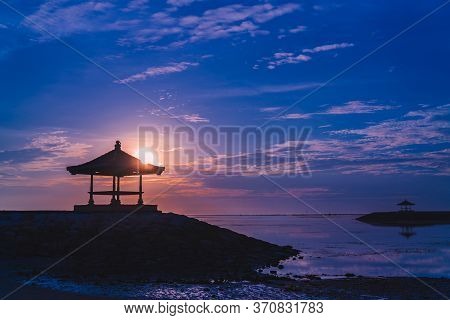 Silhouettes Of A Traditional Gazebos Against The Dawn Sky On Sanur Beach, Bali, Indonesia