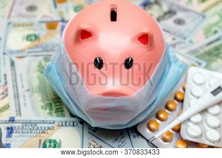Piggy Bank In A Mask On A Background Of American Currency.the Concept Of Coronavrius Epidemic
