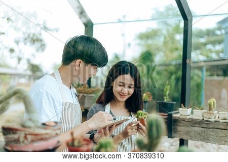 A Man Writing Note In A Book. Love Couple Enjoy Hobby With Darden Cactus.