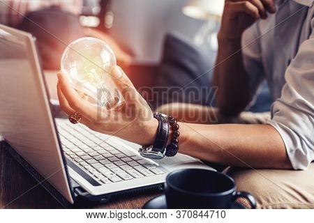 Light Blub On Businessman Hands. Idea, Strategy And Success Concept.