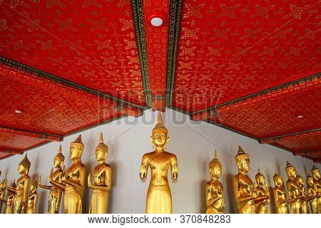Many Golden Buddha Statue Standing With Red Ceiling And White Wall At Arunratchawararam Temple The R