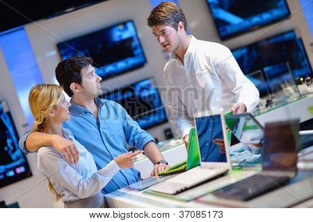 folk i forbruger elektronik detail butik ser på nyeste laptop, fjernsyn og foto kamera t