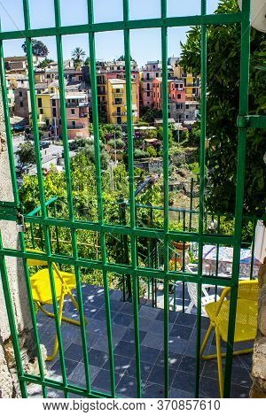 Corniglia, Italy - July 8, 2017: View Of Colorful Houses Of Corniglia Through The Garden Door