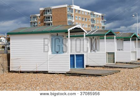 Træ beach huts på stenstrand i Bexhill-on-Sea i East Sussex, England.
