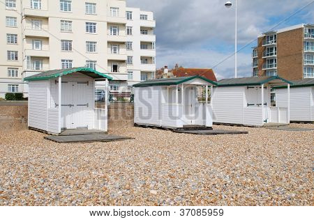Træ beach huts på stenstrand i Bexhill-on-Sea i East Sussex, England.