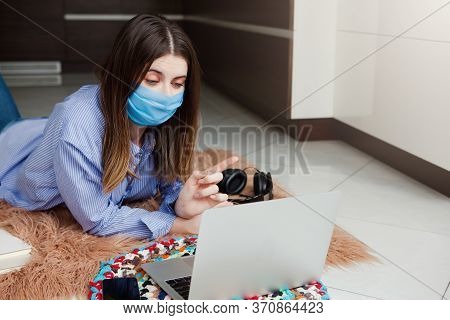 Young Woman In Medical Mask Successfully Working At Home Using Laptop. Concept Home Quarantine, Isol