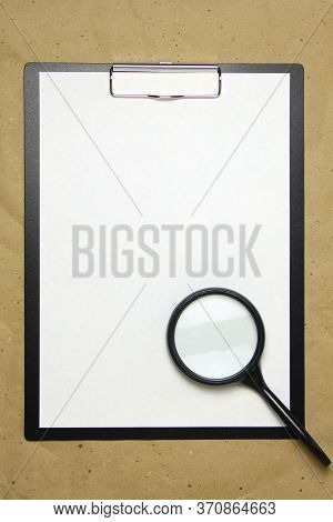 A Tablet With A White Sheet Of A4 Format With Magnifier On A Beige Craft Paper. Concept Of Analysis,