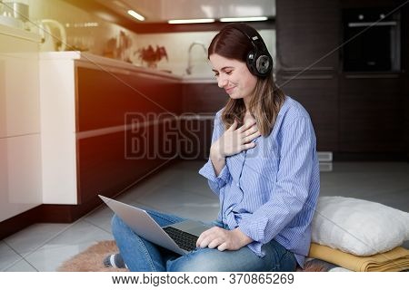 Beautiful Woman In Headphones Using Laptop, Looking At Screen, Standing In Kitchen, Happy Young Fema