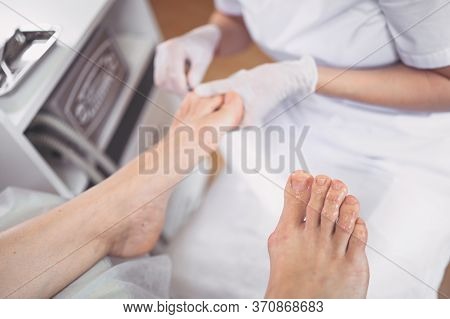 Pedicurist Doing Professional Medical Pedicure Procedure In Beauty Salon With Special Eguipment. Foo