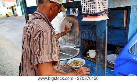 Indonesian Food, Mie Ayam, Noodles With Chicken Presented Directly By The Seller On The Cart, Unfocu